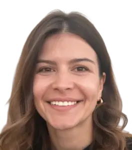 Portrait of a smiling woman with brown hair and hoop earrings, city skyline in the background.