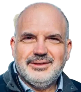 Close-up portrait of a smiling middle-aged man with a gray beard and blue jacket.